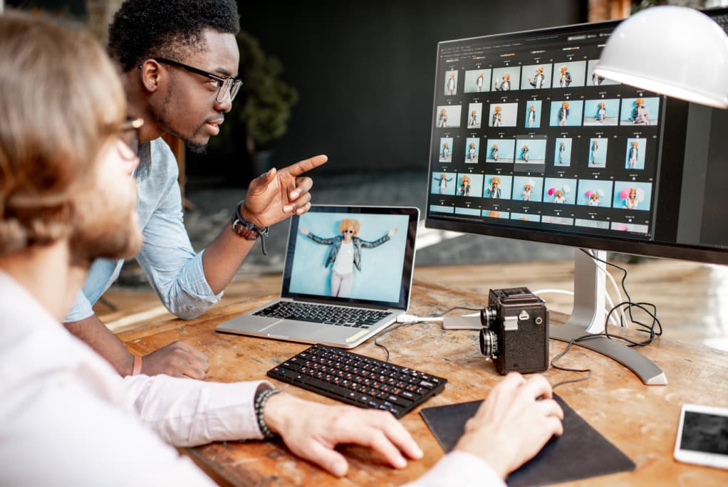 Two photographers working on computers